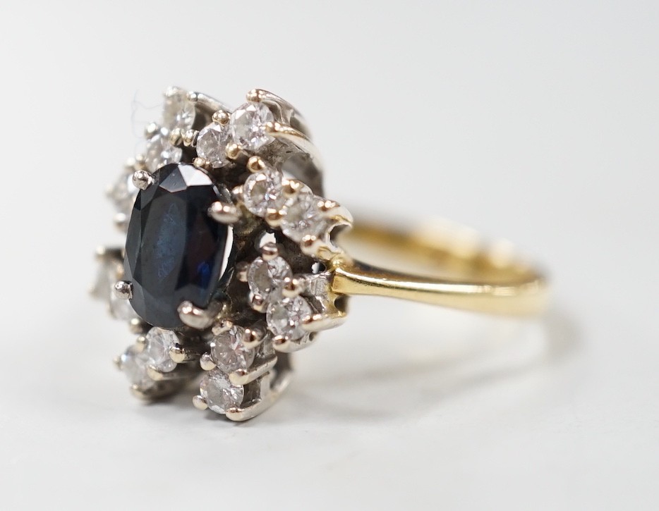 A modern 18ct gold, sapphire and diamond set oval cluster ring, size L, gross weight 4.8 grams.